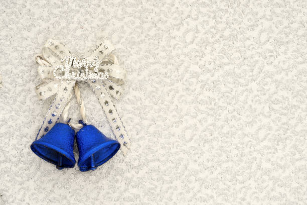 istock blue jingle bells with a silver ribbon bow and merry christmas writing on a silver background 806883630