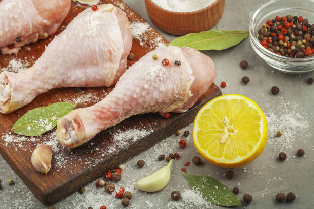 istock raw chicken legs with lemon on a wooden board 806891448