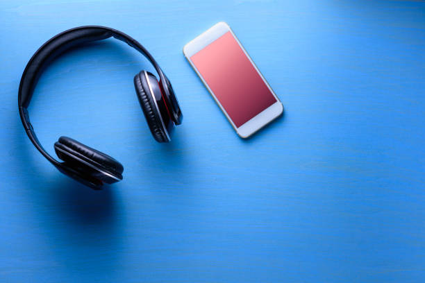 istock Wireless headphone with smartphone on blue wooden background 806903974