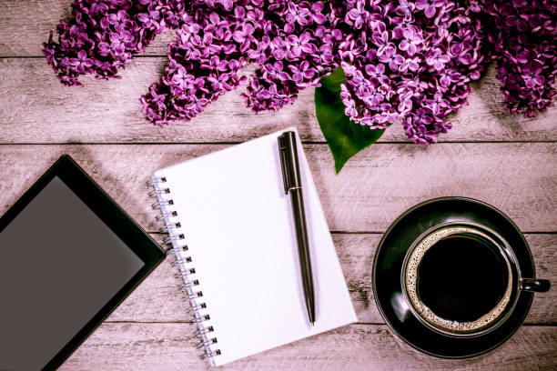 istock workspace with tablet, notebook and coffee cup. lilac on wooden table. top view with copy space. celebration template concept. 806911852