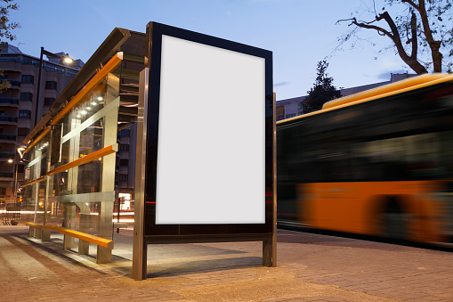 Blank advertisement in a bus stop, with blurred bus