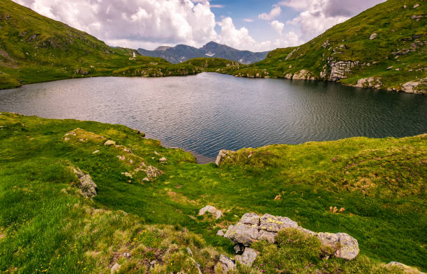 istock lake in mountains with grass on hillside 806933062