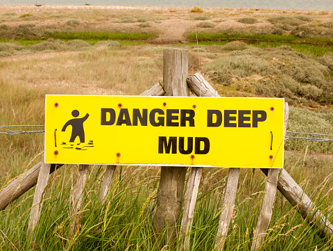 a danger deep mud yellow rectangle sign outside sea coast