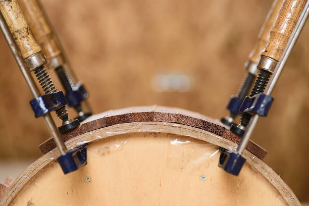 istock Handmade wooden drum shell held in clamp for glueing 806985276
