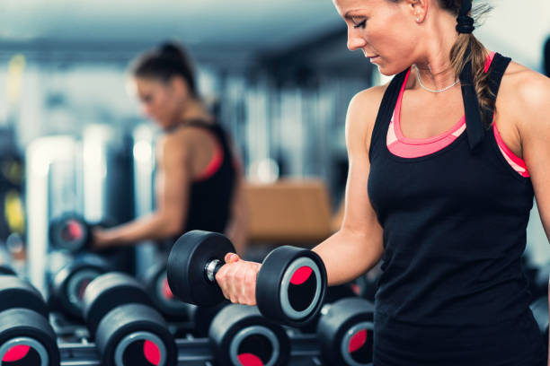 istock Young woman exercising in the gym 806999250