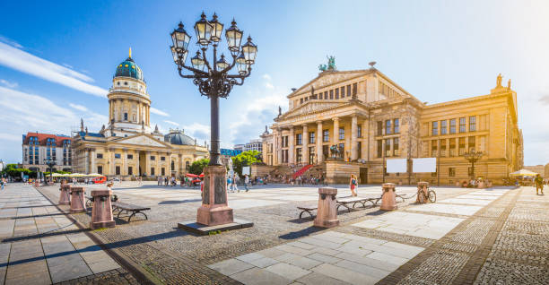 Berlin Gendarmenmarkt square at sunset, central Berlin Mitte district, Germany Panoramic view of famous Gendarmenmarkt square with Berlin Concert Hall and German Cathedral in golden evening light at sunset with blue sky and clouds in summer, Berlin Mitte district, Germany berlin germany urban road panoramic germany stock pictures, royalty-free photos & images