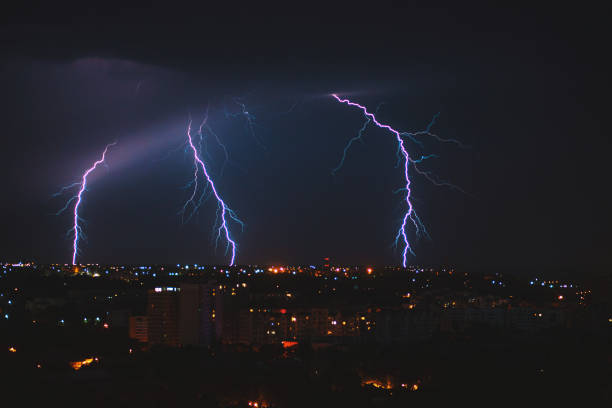 photo of beautiful powerful lightning over big city, zipper and thunderstorm, abstract background, dark blue sky with bright electrical flash, thunder and thunderbolt, bad weather concept - florida weather urban scene dramatic sky imagens e fotografias de stock