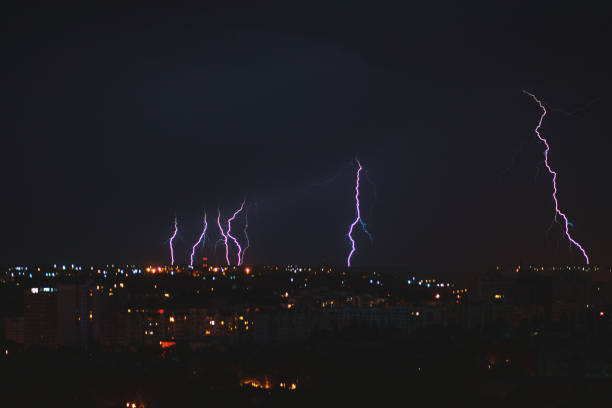 photo of beautiful powerful lightning over big city, zipper and thunderstorm, abstract background, dark blue sky with bright electrical flash, thunder and thunderbolt, bad weather concept - keyarena imagens e fotografias de stock