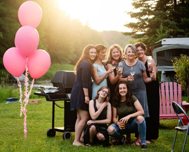 Portrait of the women of multi-generation family at barbecue. Portrait of the women of multi-generation family at barbecue. Celebration time for this real family outdoors in summer. Horizontal full length shot with copy space. This was taken in Quebec, Canada. big family sunset stock pictures, royalty-free photos & images