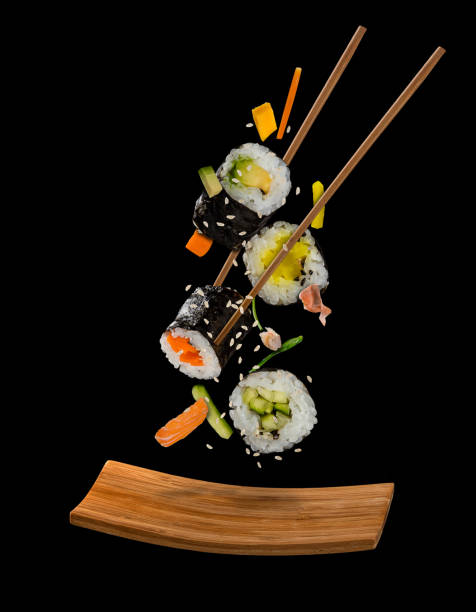 istock Sushi pieces placed between chopsticks on black background 807017118