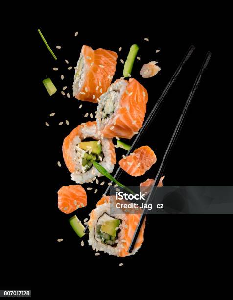 Sushi Pieces Placed Between Chopsticks On Black Background Stock Photo - Download Image Now