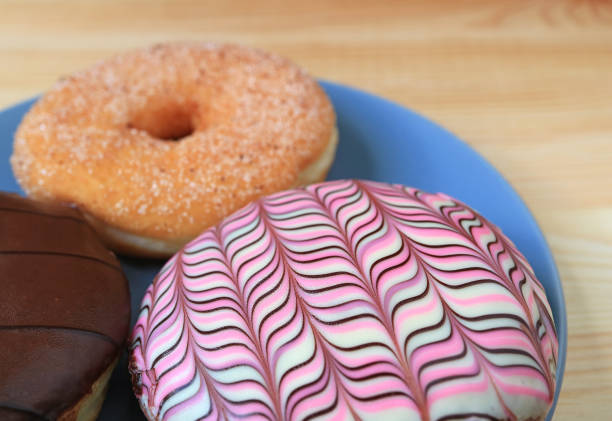 istock Closed up three types of doughnuts served on blue plate on the wooden table, with selective focus 807022922