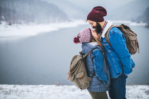 Couple on cold winter day in nature, having fun