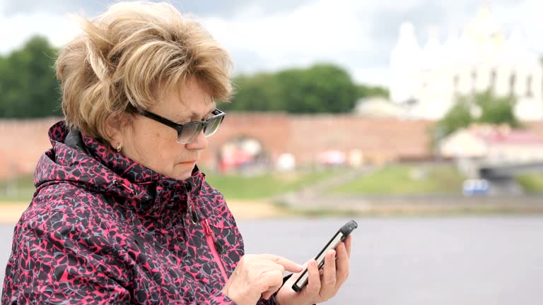 Adult woman tourist holding a smartphone outdoors