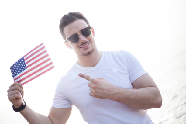 istock Young man pointing, flag ,4 th of july 807058032