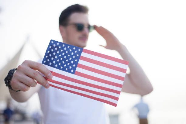 istock Young man saluting,showing American flag 807058068