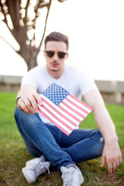 istock Young man holding flag at 4 th July , park 807058086
