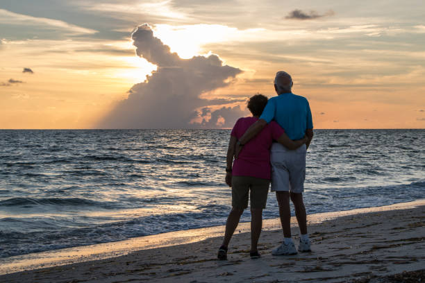 Man and a woman watching a sunset on a beach