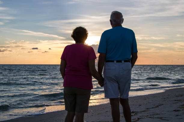Man and a woman holding hands during sunset on a beach