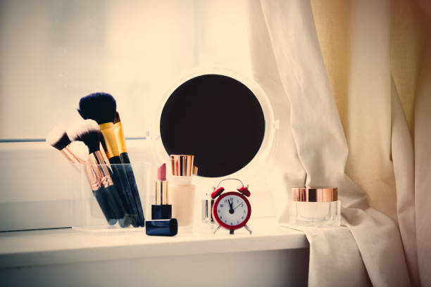 istock professional makeup set, alarm clock and cute mirror on the wonderful white windowsill 807095768