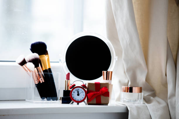 istock professional makeup set, gift, alarm clock and cute mirror on the wonderful white windowsill 807095848