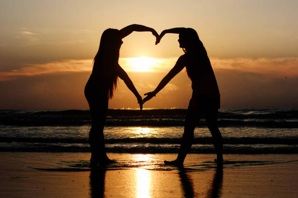 istock Two friends make heart shape with their arms 807096350