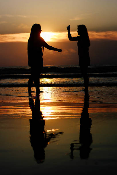 istock Women high five each other at the beach 807096392