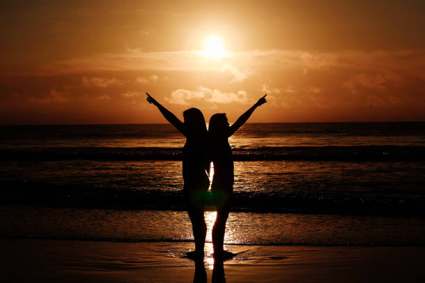 istock Women stand back-to-back on beach 807096410