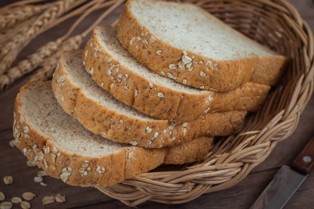pain de blé entier dans le panier en osier - bread bread basket basket whole wheat photos et images de collection