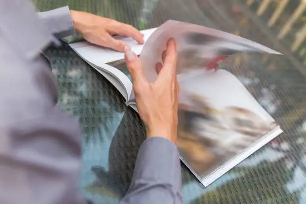 Photo of Adult men flipping a magazine page
