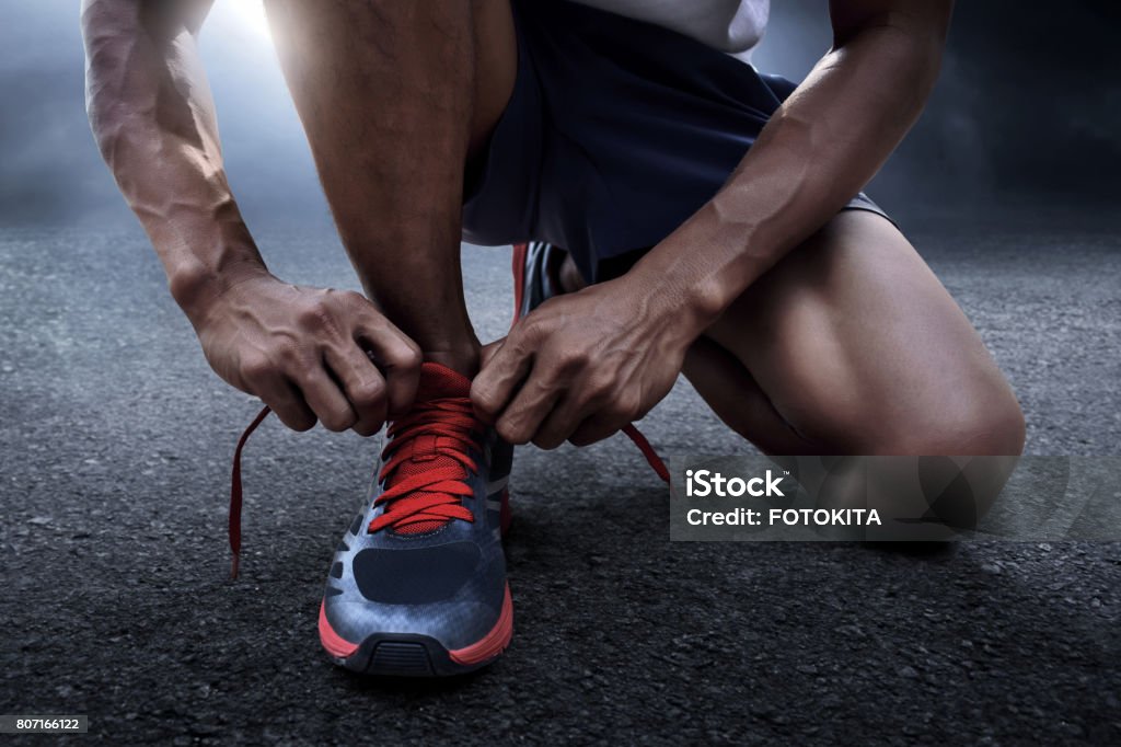 Man tying running shoes Running Stock Photo