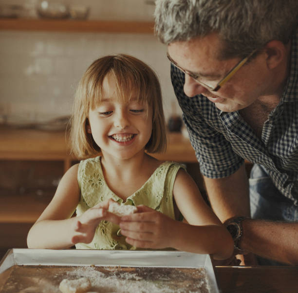 istock Little Girl Grandfather Bake Cookie Concept 807171216