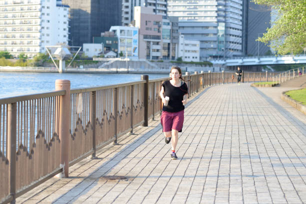 istock Woman running by the river 807185252