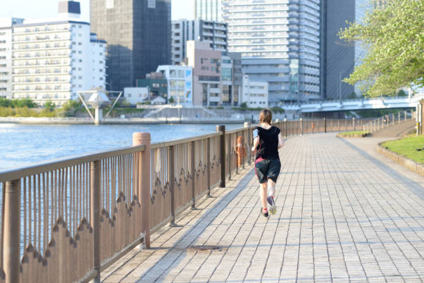 istock Woman running by the river 807185272