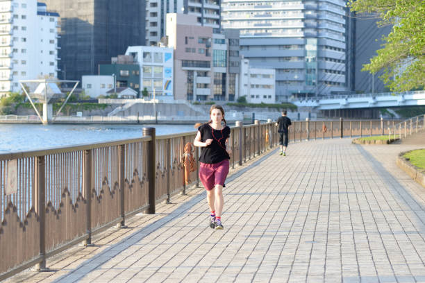 istock Woman running by the river 807185274