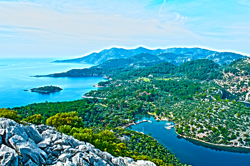 Rock in the bay of Khuzir with few trees on the background.