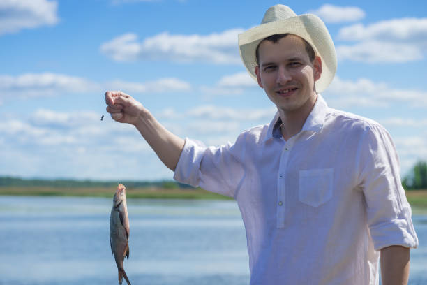 istock Man on the river in a cowboy hat caught a fish 807201984