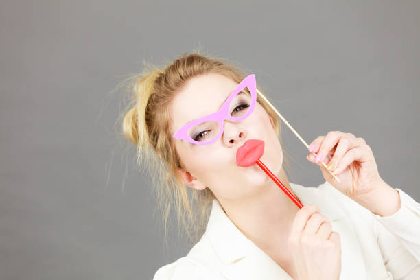 istock Happy woman holding carnival accessoies on stick 807210534