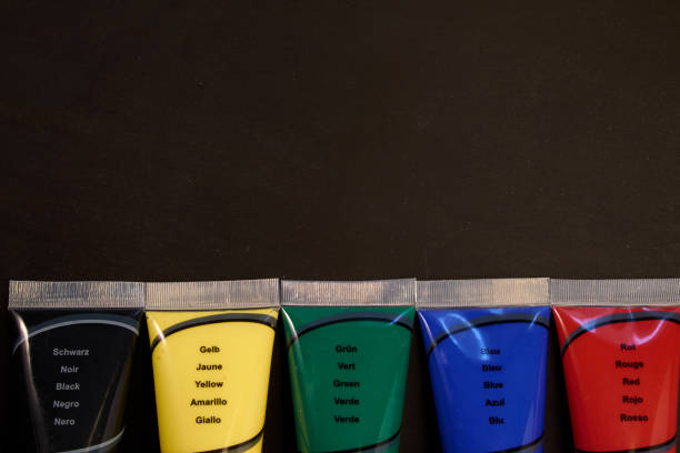 Multicolour tubes of paint on blackboard with copy space