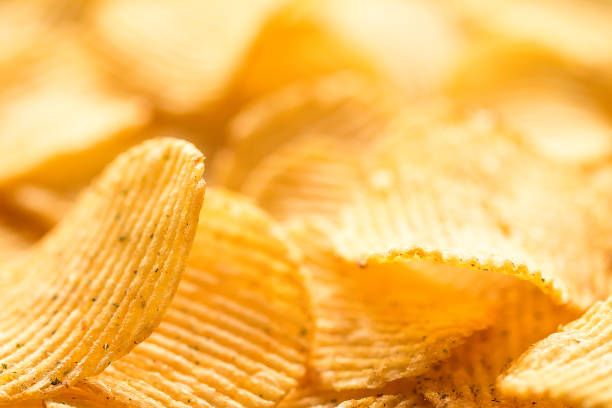 istock Yellow salted potato chips as background, closeup 807218430