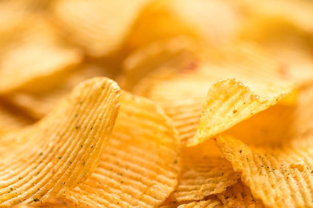 istock Yellow salted potato chips as background, closeup 807218526