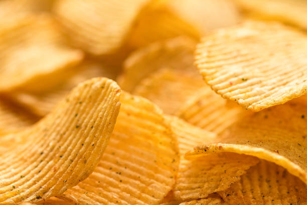 istock Yellow salted potato chips as background, closeup 807218614