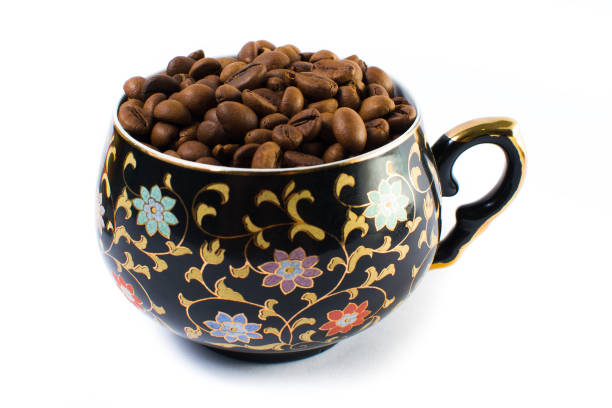 Coffee beans in a small cup on a white background. Isolated.