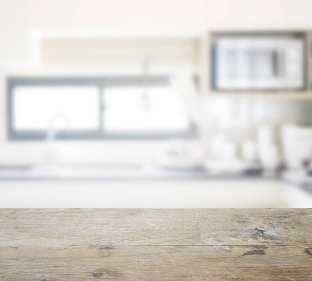 istock wooden table top with blur of modern kitchen and utensils setting on counter top 807230284