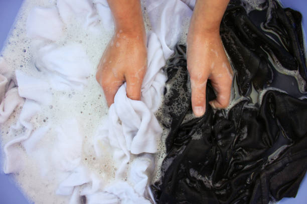 istock Female hand wash black and white clothes in same basin. 807235722