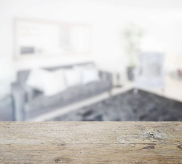 istock wooden table top with blur of modern bedroom with black sofa 807236182