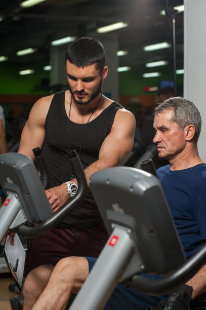 istock Personal trainer working with senior man in gym 807247350