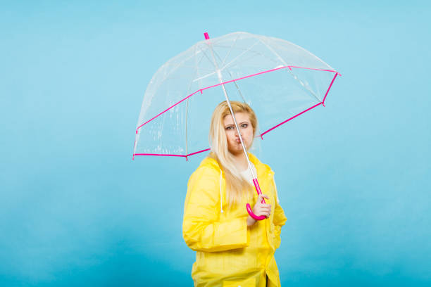 istock Sad bored woman wearing raincoat holding umbrella 807266708