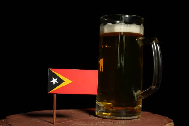 Photo of East Timorese flag with beer mug isolated on black background