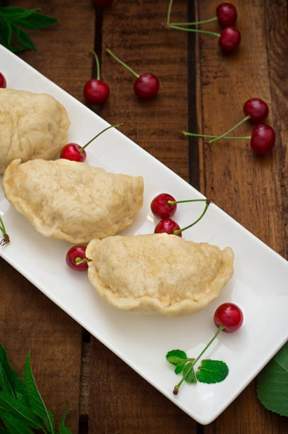 istock Homemade dumplings with cherries. Wooden rustic background. Close-up. Top view 807280408